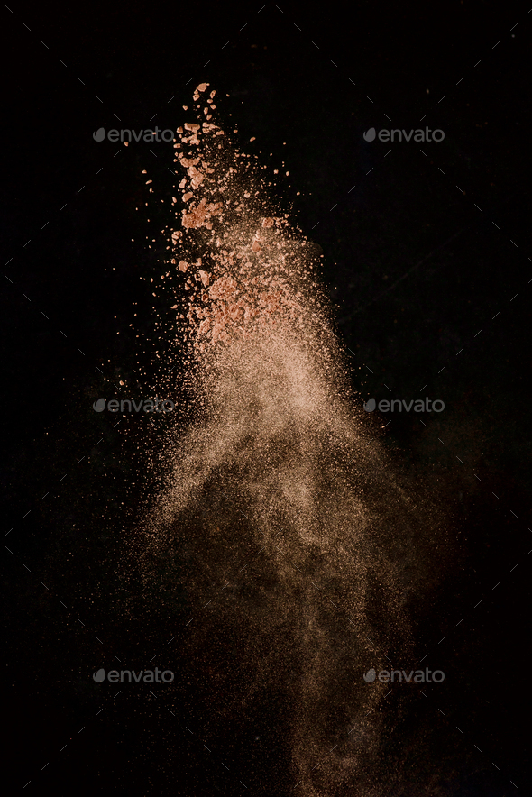 Cocoa powder explosion in motion. Chocolate dust on a black background. Action food photography